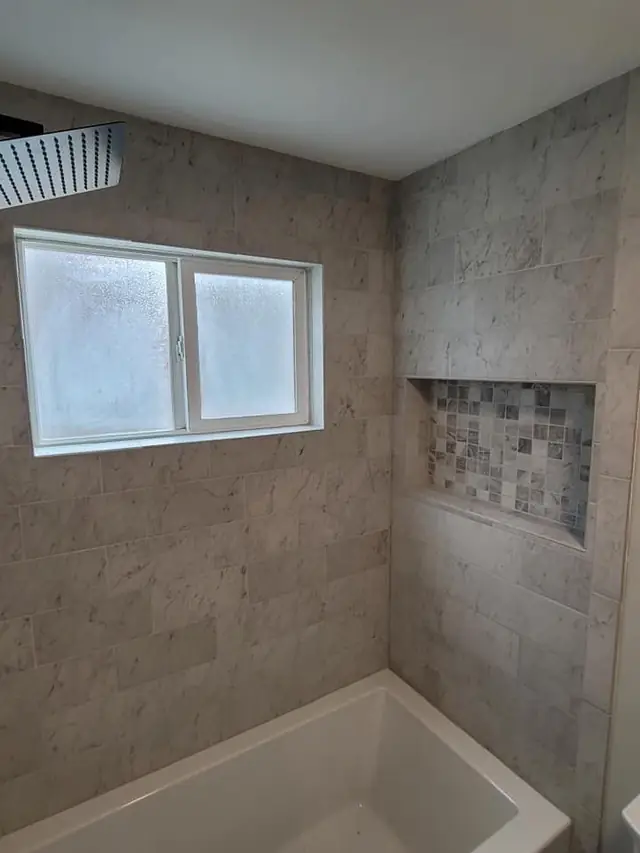 Tiled tub surround with a window and a built-in niche