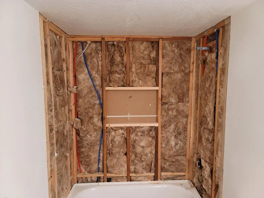 Open stud wall at a bathtub with insulation between the studs