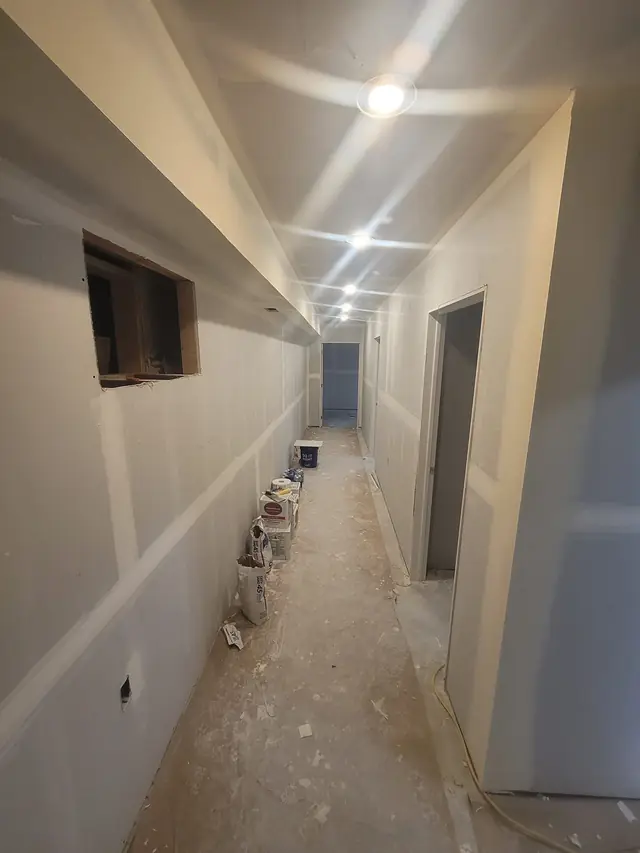 Long basement hallway with drywall hung on the walls