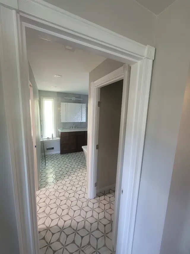 View through a white-trimmed doorway into a finished primary bathroom